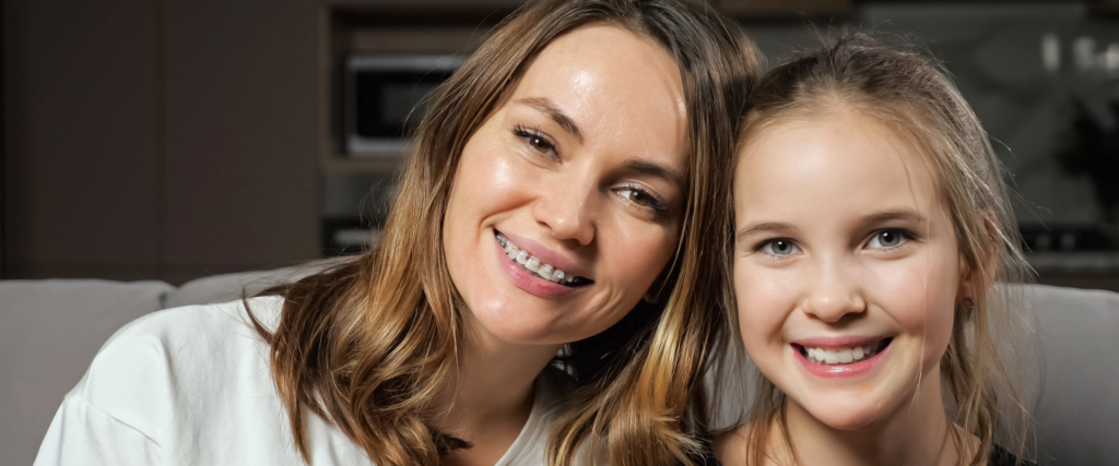 woman poses with daughter after getting braces as an adult