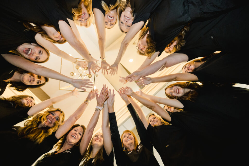 Rogers & Andrews Orthodontics team putting hands together, cheering celebrating, RAO scholarship 2026