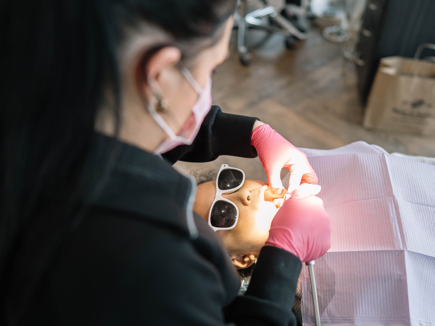 Young patient in sunglasses being treated at Rogers & Andrews Orthodontics